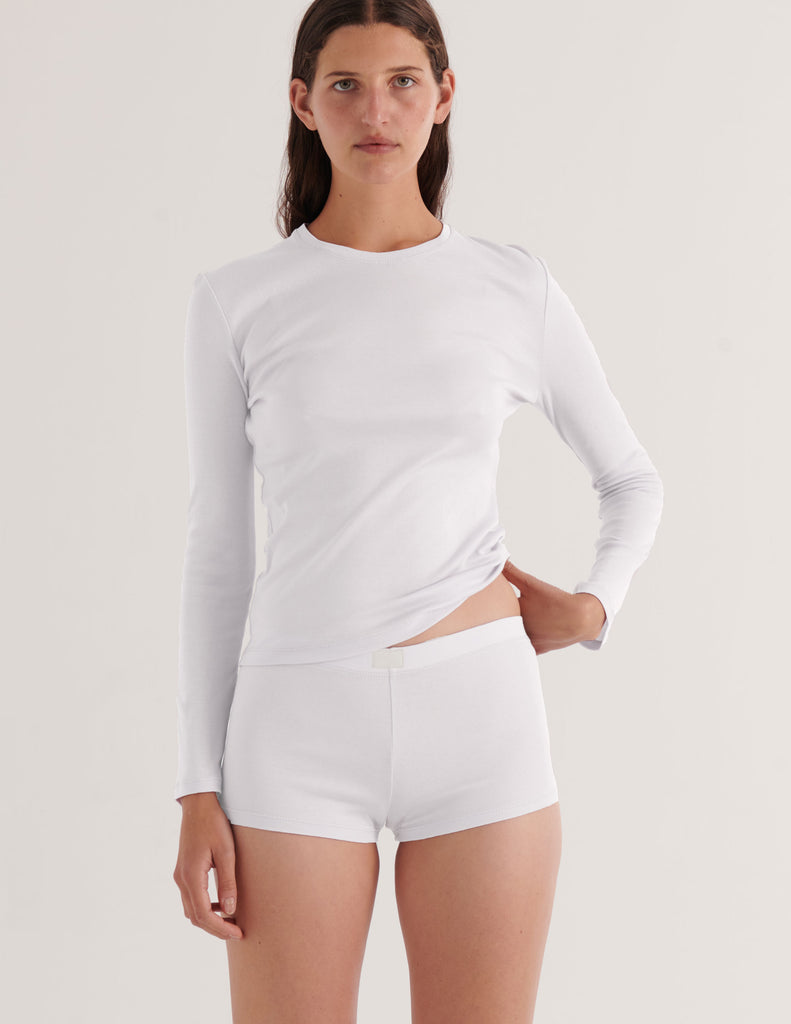 a model in the araks sabine organic cotton long sleeve shirt and presley short in white