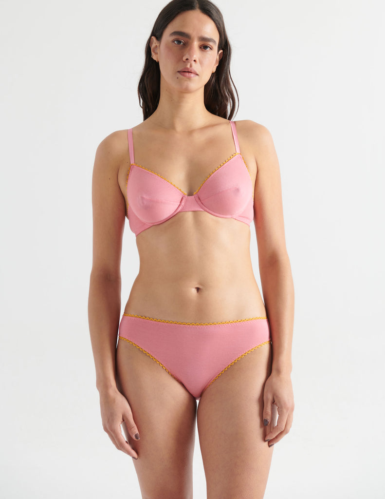 Front view image of model wearing pink cotton panties with yellow trim and matching pink cotton underwire bra. . 