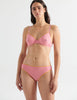 Front view image of model wearing pink underwire bra with yellow trim and matching panty. 