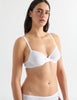 Detail view image of model wearing white cotton underwire bra with white trim. 