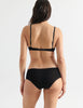 Back view image of model wearing black cotton underwire bra with black trim with matching hipster panty. 