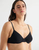 Detail view of model wearing black cotton underwire bra with black trim. 