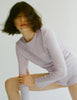 Person wearing an Araks 100% Organic cotton light purple long-sleeve top and shorts on a plain background