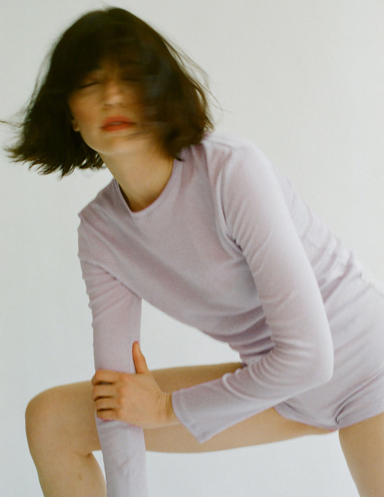 Person wearing an Araks 100% Organic cotton light purple long-sleeve top and shorts on a plain background