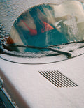 Car windshield with ice, reflecting a person in a red slip.