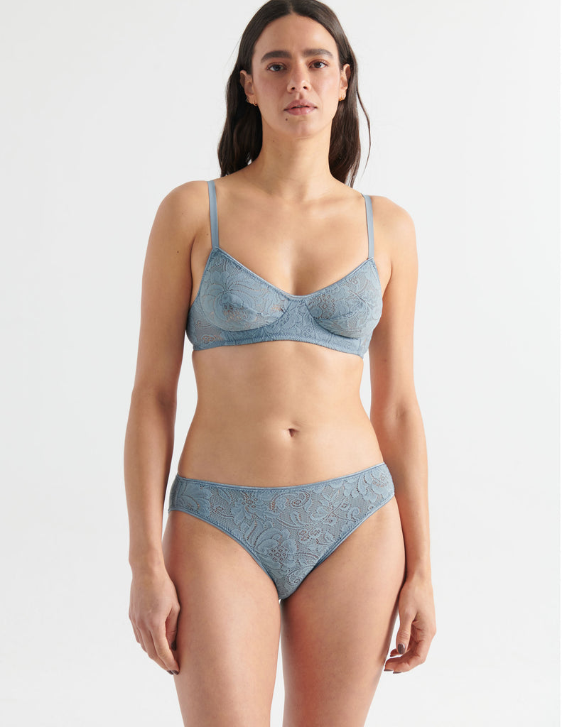 Front view image of model wearing grey lace panties with matching bralette. 