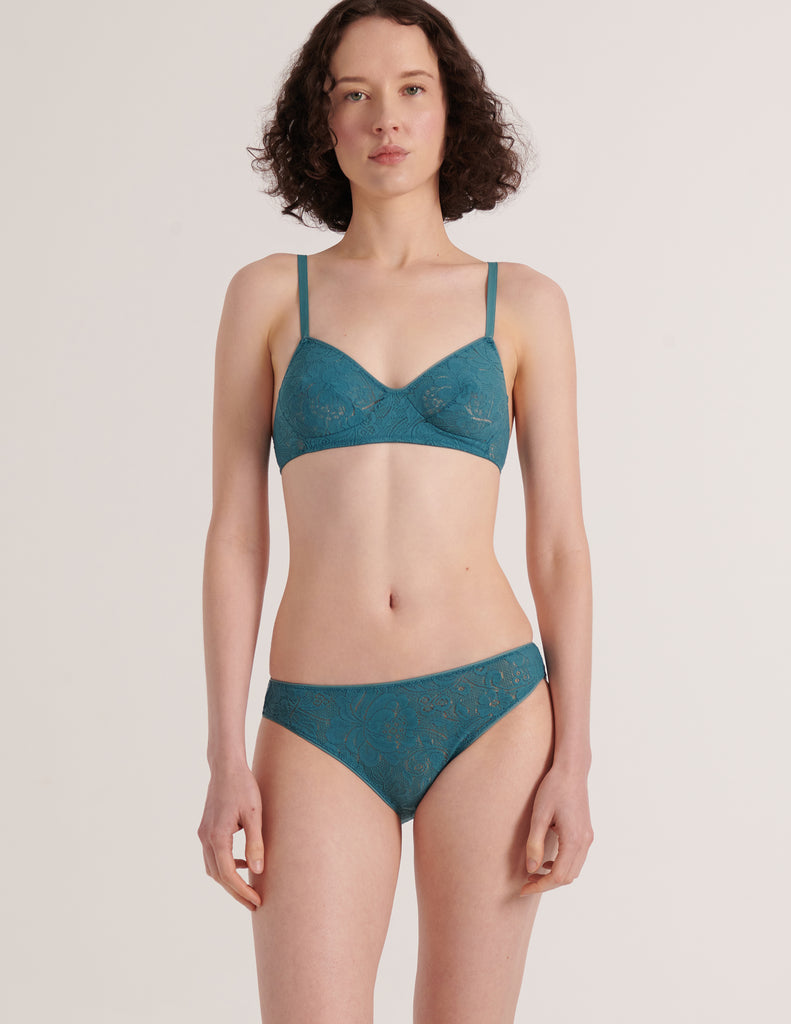 A model from the front view in the araks french stretch lace tamara bralette and tris panty in heron blue