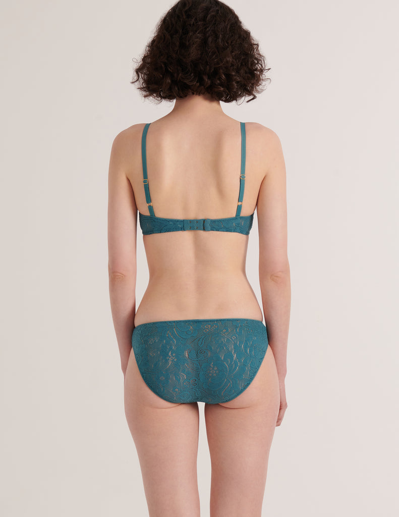 A model from the back view in the araks french stretch lace tamara bralette and tris panty in heron blue