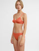 three quarter of woman in orange bra and thong