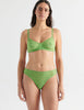 Front view image of model wearing green lace bralette with matching thong. 