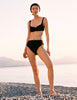Model wearing Araks Ulija bikini top and Tonne bikini bottoms in black