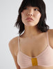 detail of woman wearing peach cotton bra