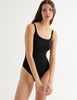 Woman wearing a black swimsuit against a white background