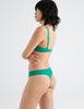 three quarters back view image of model wearing green lace bra and thong