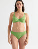 Front view image of model wearing green lace underwire bra with matching panties. 