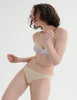 Woman wearing an Araks cotton cream bralette with a  panty against a white background