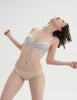 Woman wearing a Araks cream cotton bralette  and harriet cotton panties set on a white background