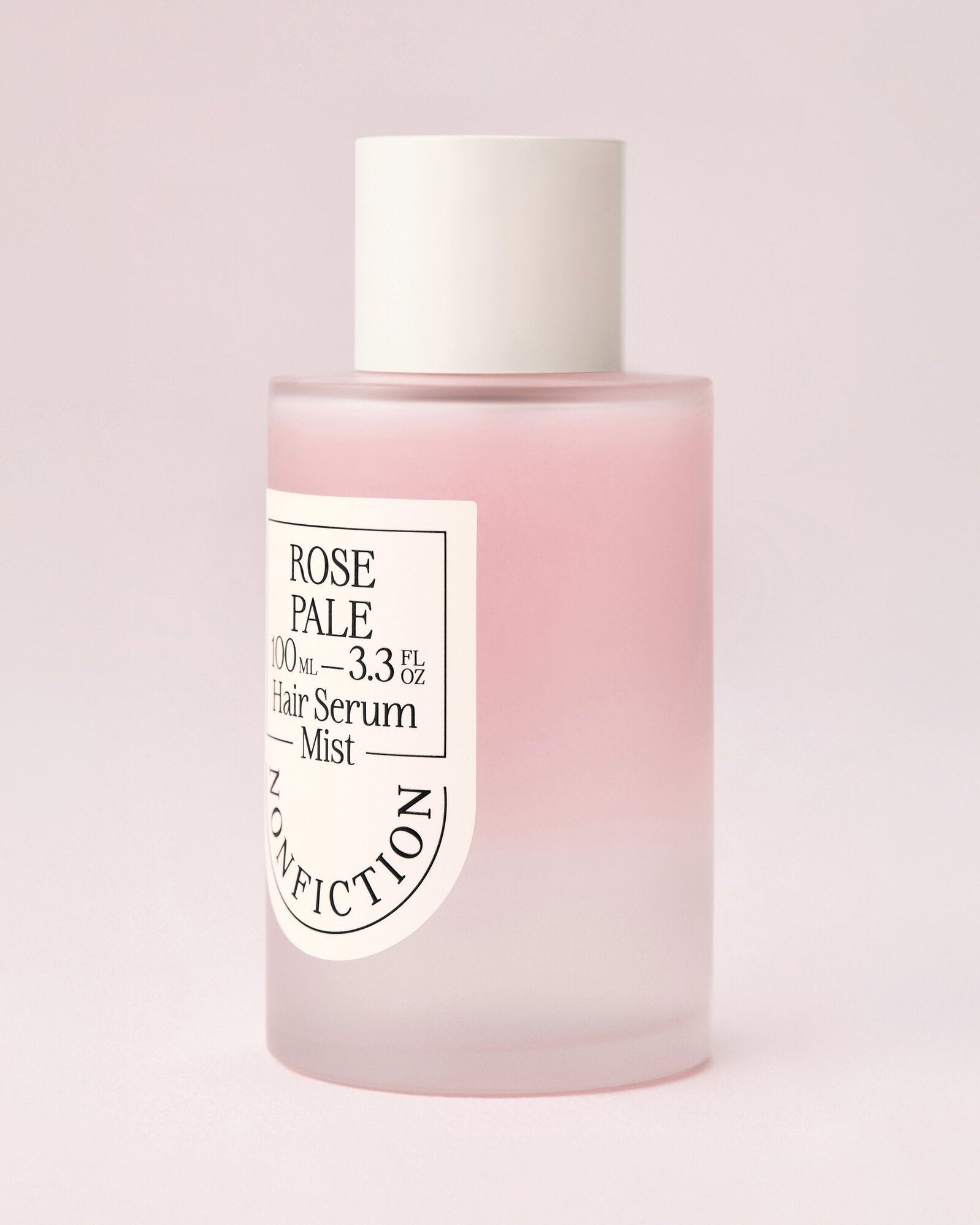 Rose Pale hair serum mist bottle on a light pink background