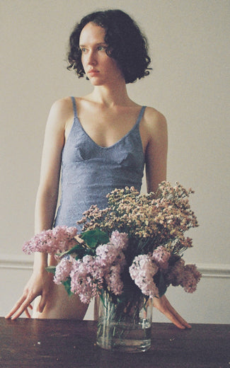 A model wearing the Georgia lace cami in dusty blue.