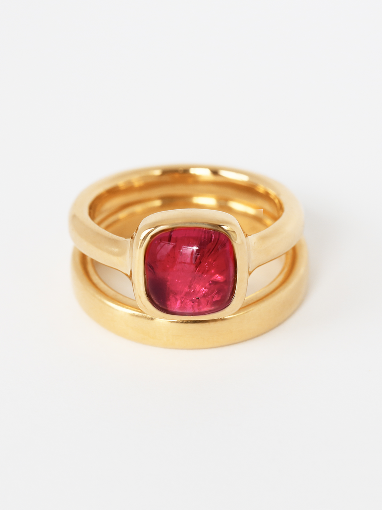 Image of Sophia Ring in solid 18k gold with soft edged square shaped pink tourmaline rubellite solitaire cabochon gem stone, stacked on top of solid 18k yellow gold Essential Band. 