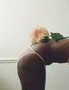 Editorial image of model wearing pink/nude lace panty (bent over profile with flower on back)