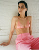 On model, editorial image, orange silk triangle bra and pink trousers