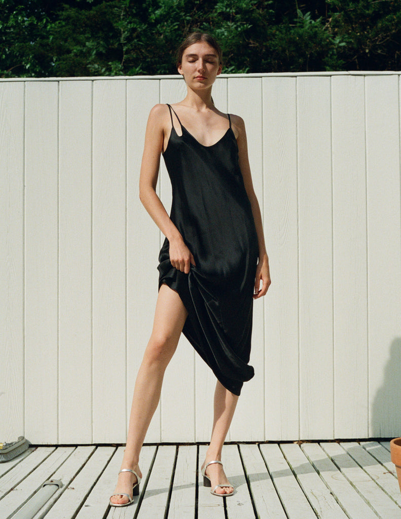 A woman wearing a black silk slip.