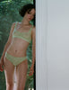 A woman wearing a green lace bra and panty 