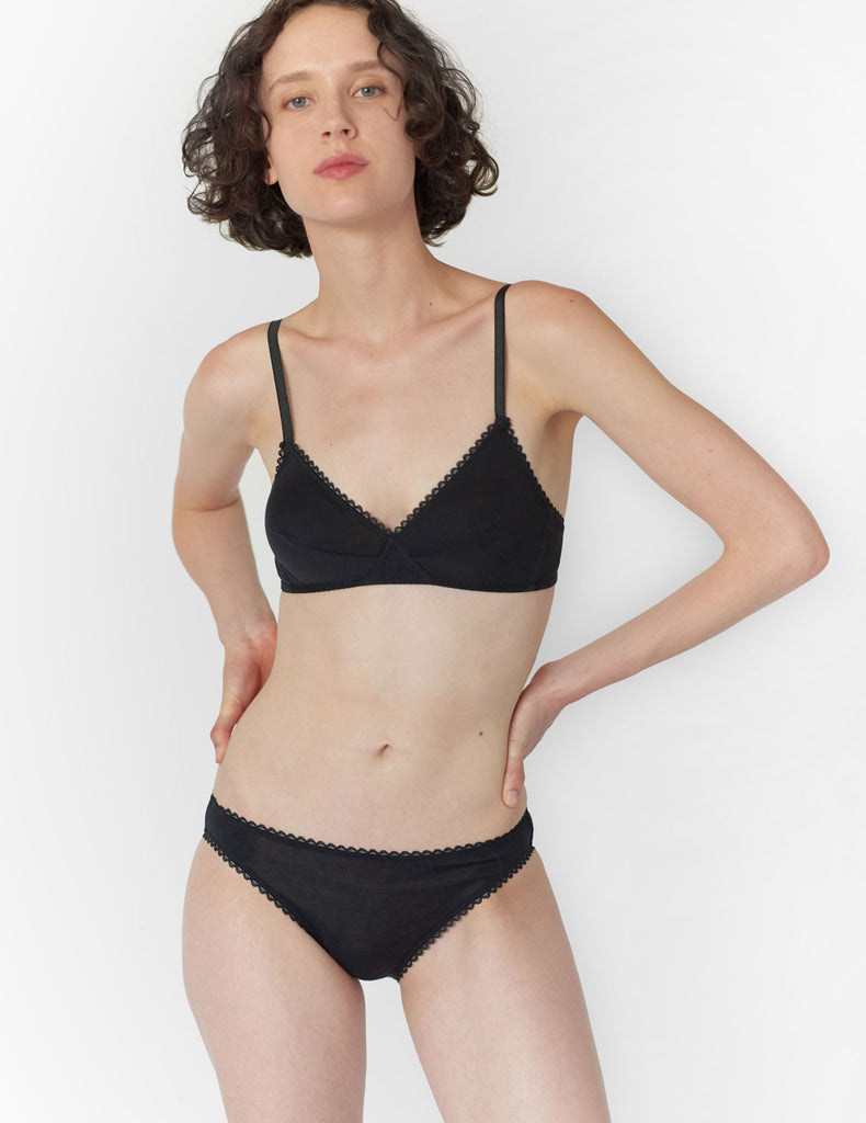 Front view of woman wearing black bralette with black trim and matching panty.
