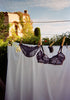 Black gingham mesh bralette and matching panty hung on clothesline outside. 
