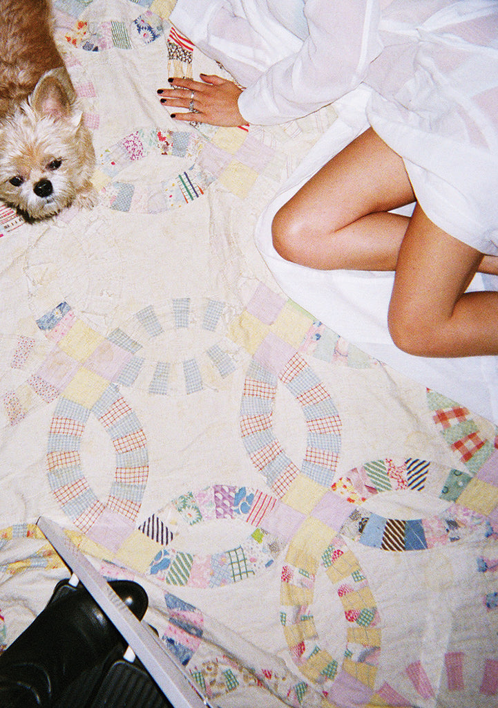 Woman laying on floor with a dog wearing white silk robe.