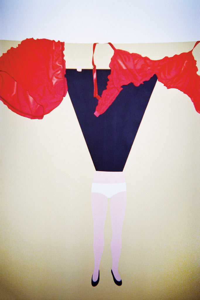 Red bralette and matching panty draped over a painting. 