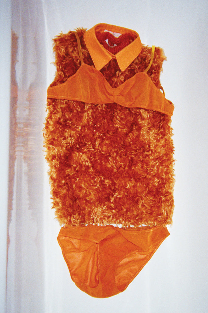 A fur shirt displays a light orange bralette and matching panty