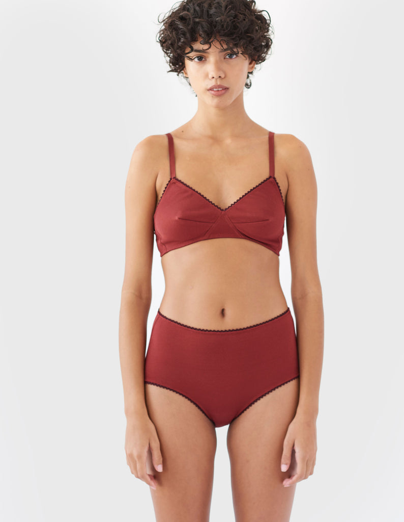 woman wearing red cotton wireless bralette with brown trim and matching high waist  panty