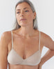 Front view of a woman wearing nude araks organic cotton antonia bralette with nude trim.