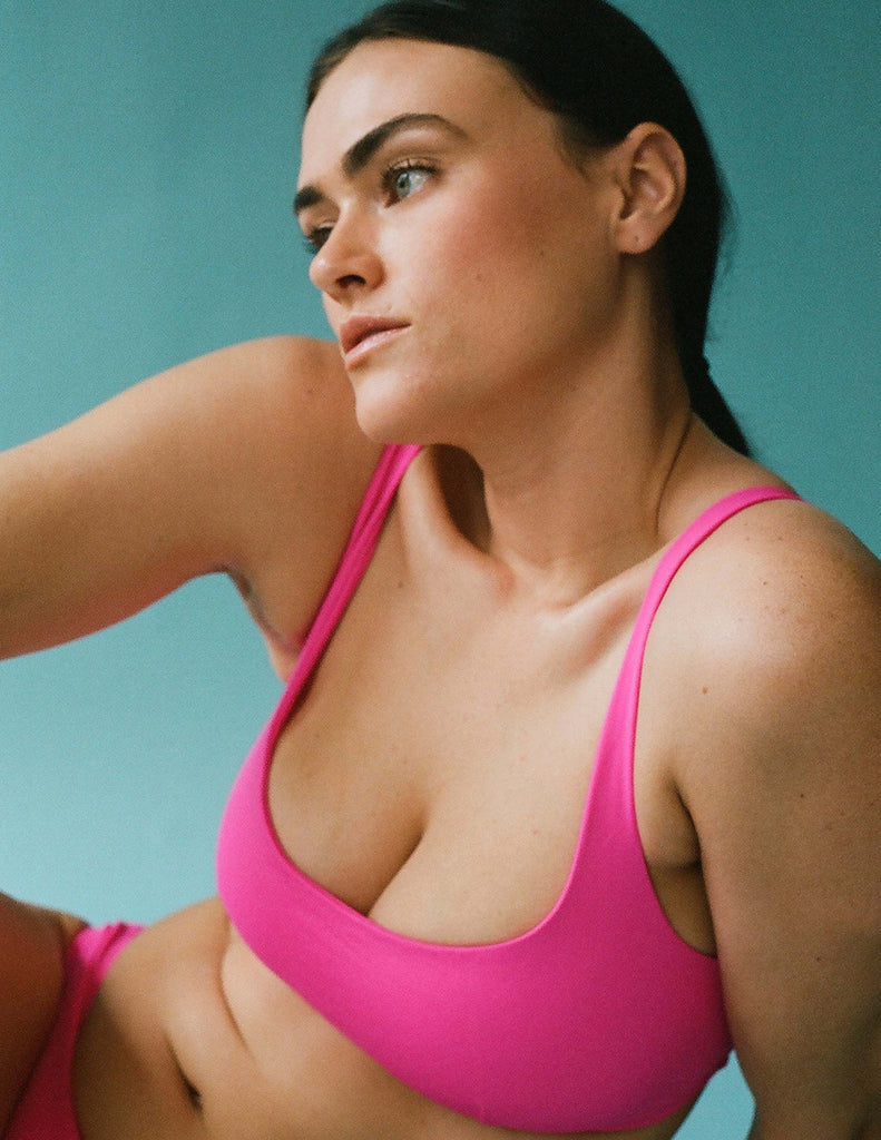 Front view of woman wearing pink bikini top.