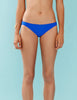 Woman wearing royal blue low-rise swim bottoms.