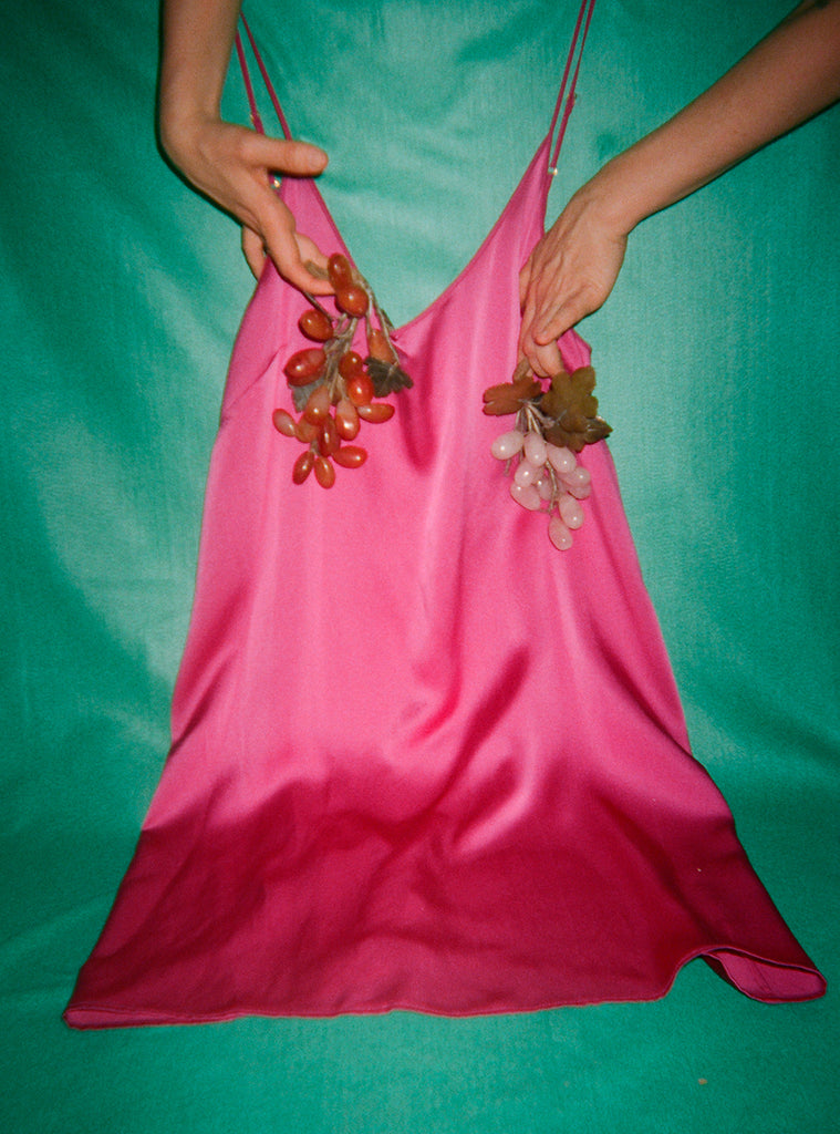 Model holds fruits, displaying a pink slip