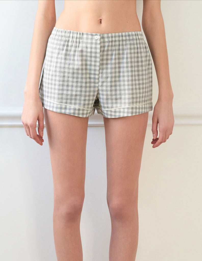 Woman wears light grey cotton boxer shorts with contrast piping 