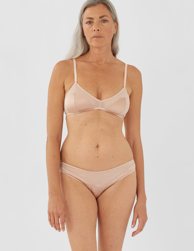 Front view of woman wearing beige bralette and matching panty.