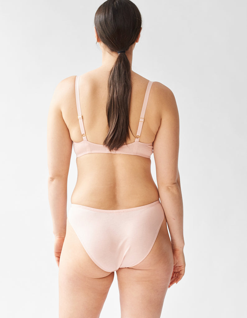 back view of a woman wearing beige underwire bra and matching panty