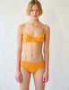 On model image of orange underwire bra and panty