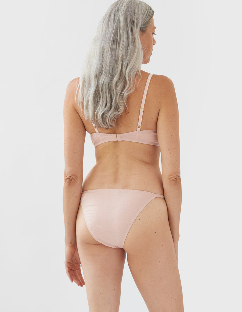 back of woman wearing beige wireless bra and matching panty