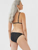back of woman wearing black lace triangle bra and matching string panty