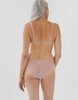 back of woman wearing beige lace triangle bra and matching string panty
