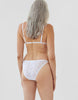 back of woman wearing white lace triangle bra and matching string panty