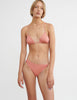 woman wearing pink triangle bikini top with knotted back and matching bottom by Araks