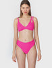 woman wearing pink bikini top with asymmetric crisscross straps and matching bottom by Araks