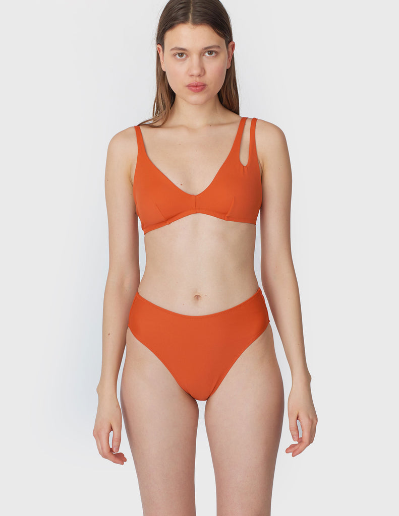 Back view of woman wearing a orange bikini bottom with matching orange bikini top