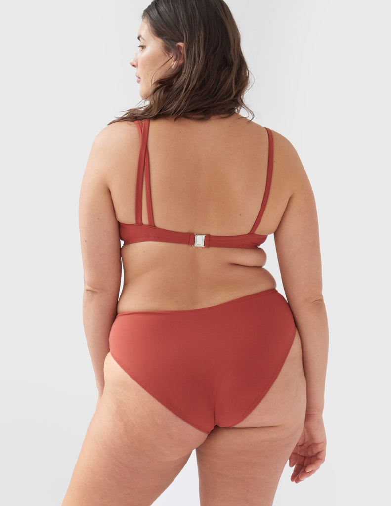 Back view of woman wearing a red bikini bottom with matching red bikini top